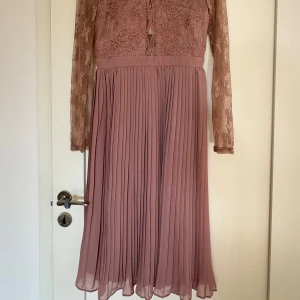 Vacker festklänning (oanvänd) Nypris 999kr - Vacker klänning från Nelly EVE. Oanvänd, i färgen rosé Passar till fest eller bröllop 