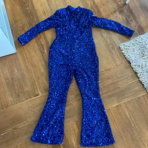 Säljer denna blåa jumpsuit med Bootcut och axelvaddar samt öppen rygg från boohoo! Säljes pga av att den var för liten och gick ej att returnera så vill bara bli av med den:) Kom med bud