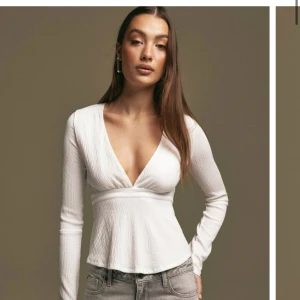 Sommar blus - Super fin vit blus från Nelly. Oanvänd. Med knytning i midjan. Går att välja att ha den fram eller bak.lappen sitter kvar Nypris 299