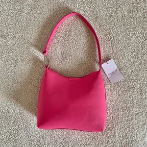 Stockhlm Studio rosa väska - Väldigt fin väska från Stockholm Studio som inte kommit till användning ännu. Ordinariepris 499kr. Prislappen lossnade i bagaget på en resa men den är oanvänd.