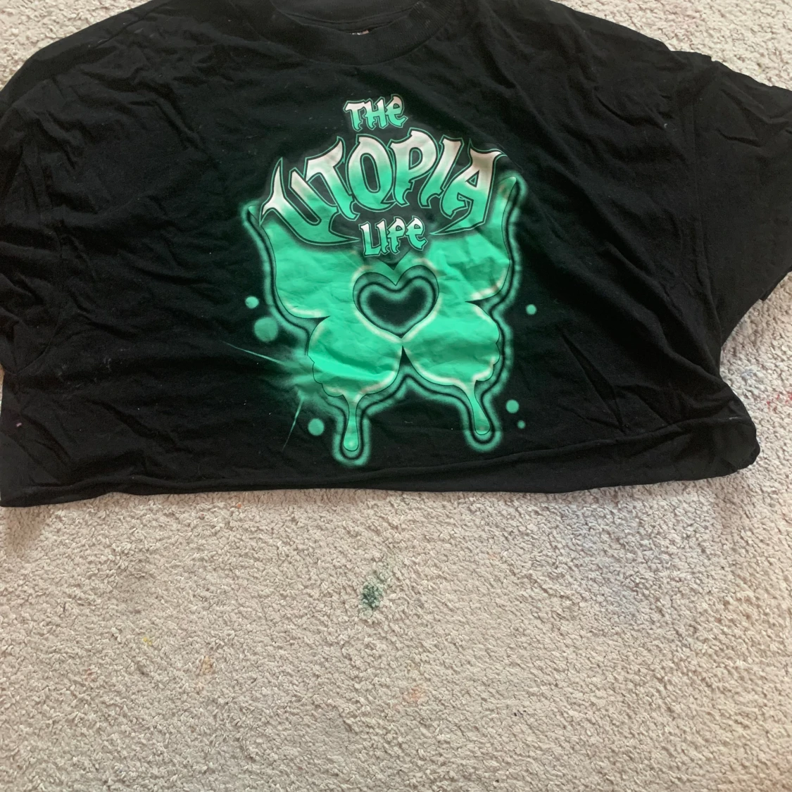 Svart croptopp med grönt tryck. 