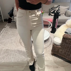 Beiga jeans  - Jeans med slits längst ner med en liten defekt på ena benet som kanppt syns.