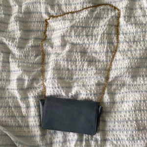 Väska - Blå väska med guldkedja från Åhléns. Nästan aldrig använd!!