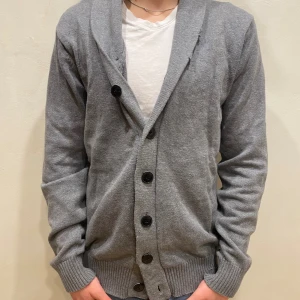 Kofta Jack & Jones  - Kofta Jack & Jones   Modell: 184cm & väger 84kg Skick: allmänt använd  Färg: Grå  Material: bomull