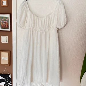 Studentklänning  - En vacker vit klänning som passar perfekt som student- eller sommarklänning! Använd 1 gång och är som ny. Storlek L men passar säkert flera eftersom den inte är åtsittande och är med resor i midjan och ärmarna. Underkjol, därför syns det inte igenom💓