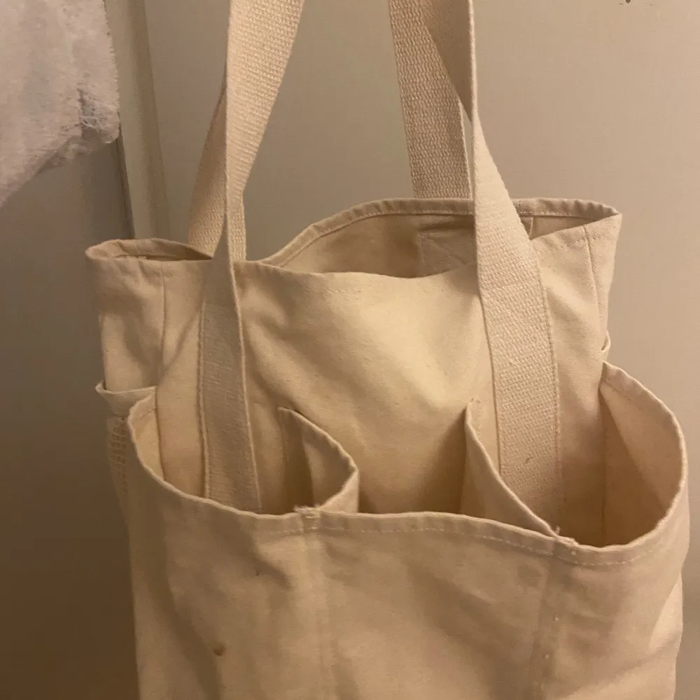 Snygg väska/tygpåse med 9 olika fack Passar perfekt som datorväska, gymbag, handväska eller när man reser!  Fin beige/linne färg. Väskor.