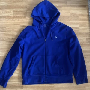 Polo Ralph Lauren zip Hoodie - Väldigt fint skicka, sparsamt använd. Säljes pga att jag inte använder den så mycket längre. Storlek L 180/100A Priset är diskuterbart Nypris ungefär 2200kr Kan mötas upp i Alingsås. Kvitto finns.