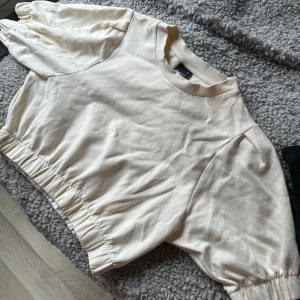 Kort tröja  - Fin tröja från Gina med mudd på armarna och runt magen. Slutar precis över höfterna. 