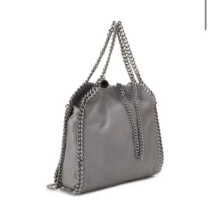 Stella mccartney väska - Säljer då den aldrig kommer till användning. Super fint skick, inga skafor. Kedjan har börjat få lite missfärning men inte alls mycket, därav billigt pris. 