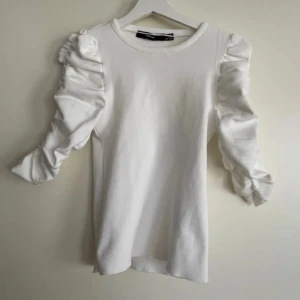 Puffärm tröja - En vit t-shirt från vero Moda med puffärm liknade armar. Jätte söt tröja men säljer för den ej kommer till användning,(använd ca 3 gånger)