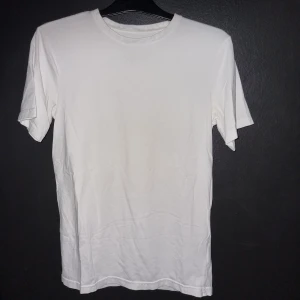 Vit t-shirt från BLWR - Säljer en vit t-shirt från BLWR i storlek M. Den är enkel och stilren, perfekt för vardagsbruk eller som basplagg. T-shirten är gjord av bomull och har en normal passform. Den är kortärmad och passar bra till både jeans och shorts. Perfekt för sommaren eller som ett lager under en tröja.