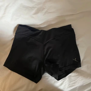 Träningsshorts - Svarta träningsshorts från decathlon. Har klippt bort lappen så vet inte exakt storlek, tror att det är barnstorlek. Skulle gissa att de passa s/xs/170/158-164. Använda så paljetterna på baksidan har tappat lite färg, men annars fina💕