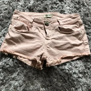 Jättesöta shorts - Säljer de här söta rosa lågmidjade shortsen då de är för små för mig. De har en jättesöt knapp formad som en ros. Dragkedjan är trasig men den går nog att laga (det syns inte när man har på sig dem. Storleken står inte men skulle säga xs💕