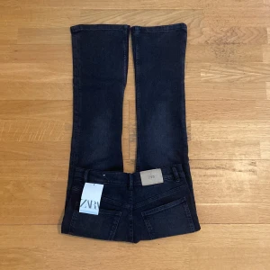 Svarta jeans - Säljer ett par svarta bootcut jeans från Zara i storlek 13-14 år (164 cm). Jeansen är i nyskick och har en snygg passform med en lätt utsvängd bootcut-stil. Perfekta för både vardag och fest!
