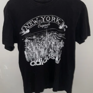 Svart T-shirt!! - Skit snygg svart T-shirt med vitt adidas tryck!!  Nypris: okänt Denna T-shirt säljs inte längre någonstans.