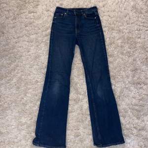 Ett par mörkblåa högmidjade, bootcut jeans i storlek 34. De är använda ganska måndag gånger men är i bra skick!