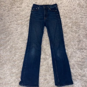 Mörkblå jeans  - Ett par mörkblåa högmidjade, bootcut jeans i storlek 34. De är använda ganska måndag gånger men är i bra skick!