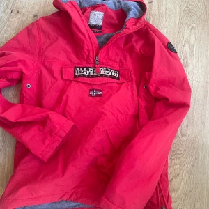 Napapijri jacka  - Napapijri jacka röd  Storlek 170 Använd två veckor i fjällen Finns ett litet svart märke på ena armen Nypris 1700kr Nu 350kr