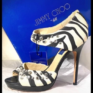 Jimmy Choo med bling! NYA!  - Helt oanvända fantastiskt fina Jimmy Choo stiletter med lapparna kvar. De kommer från Choo’s samarbete med HM och har bara stått i garderoben sedan dess. De känns dock enormt sköna! Skorna säljs med dustbag och original kartong. Stl 40 