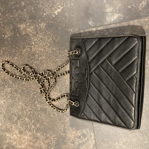 Tory burch väska - Svart handväska från Tory Burch. Fräsch och fint skick på insidan. Svart väska med guldig kedja. Väskan är i slitet skick därav billigt pris. Köpt för 4000.