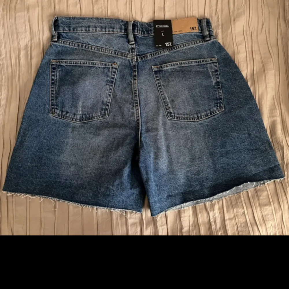 Högmidjade jeans shorts med prislapp! Aldrig använda! Sann i storlek. Den har flera knappar som man kan knäppa shortsen med, men de syns inte när man knäpper dem (se bilder).. Shorts.