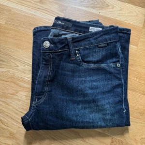 Mavi jeans - Ett par mörkblå, lågmidjade bootcut jeans från Mavi, Zalando. De heter ”Bella Midrise bootcut”. Väldigt fina i kvaliteten och bra skick förutom lite slitningar vid fötterna (sista bilden). Innerbenslängden 88cm. Ordinariepris 629kr