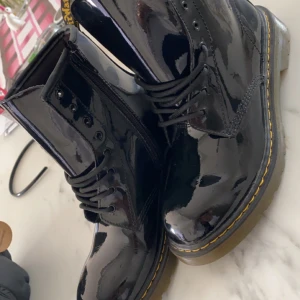 Dr martens skor - Nästan aldrig använda. Är som helt nya skor. Glansigt material och dragkedja. 