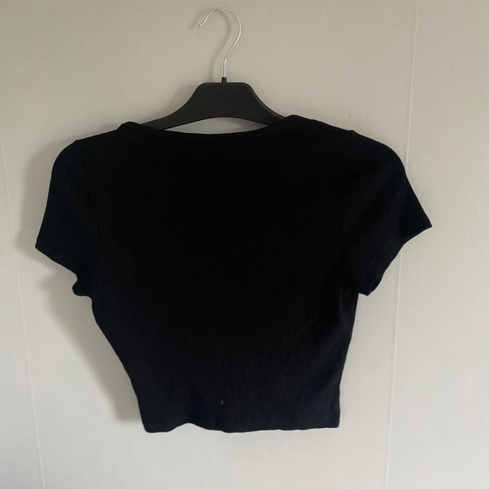 En svart ribbad tshirt från H&M i storlek M. Använd 1 gång som ny🌟🫶. T-shirts.