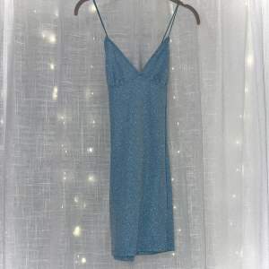 V-ringad glittrig klänning som aldrig använts och har prislappen kvar. 