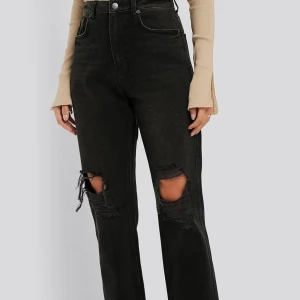 Svarta raka jeans - Svarta/mörkgråa raka jeans med slitna knän, högmidjad. Använd fåtal gånger. Pris kan diskuteras!!