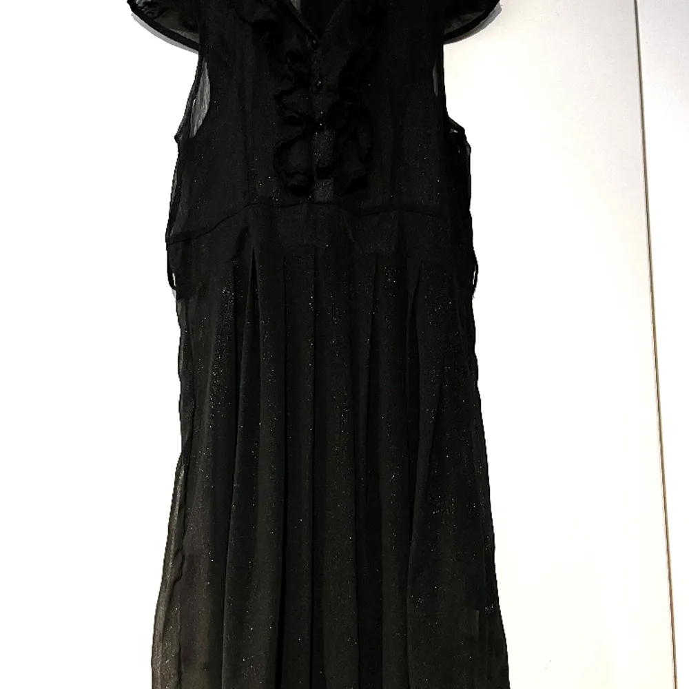 Fin svart ngt glittrig knälång klänning. Använd endast ett fåtal gånger. Ngt genomskinlig. Underklänning behövs(ingår ej). Klänningar.