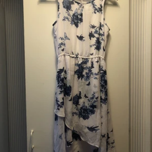 Sommarklänning - Sommarklänning från Kappahl i storlek 164. Endast använd en gång så den är som ny! Klänningen är vit med blått mönster🦋😊