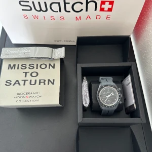 Omega X swatch klocka - tja, Säljer nu min helt nya klocka som aldrig är använd och är i 10/10 i skick, allt medföljer, man får med 2st länkar vilket är den vanliga till klockan och en annan grå länk , hör av dig vid minsta lilla fråga 🤝🏽🙌🏽