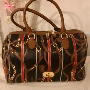 Så snygg och stilren handväska i skinn från Ralph Lauren  i klassiska färger med kedjor och tofsar .Svår att få tag på ! 
