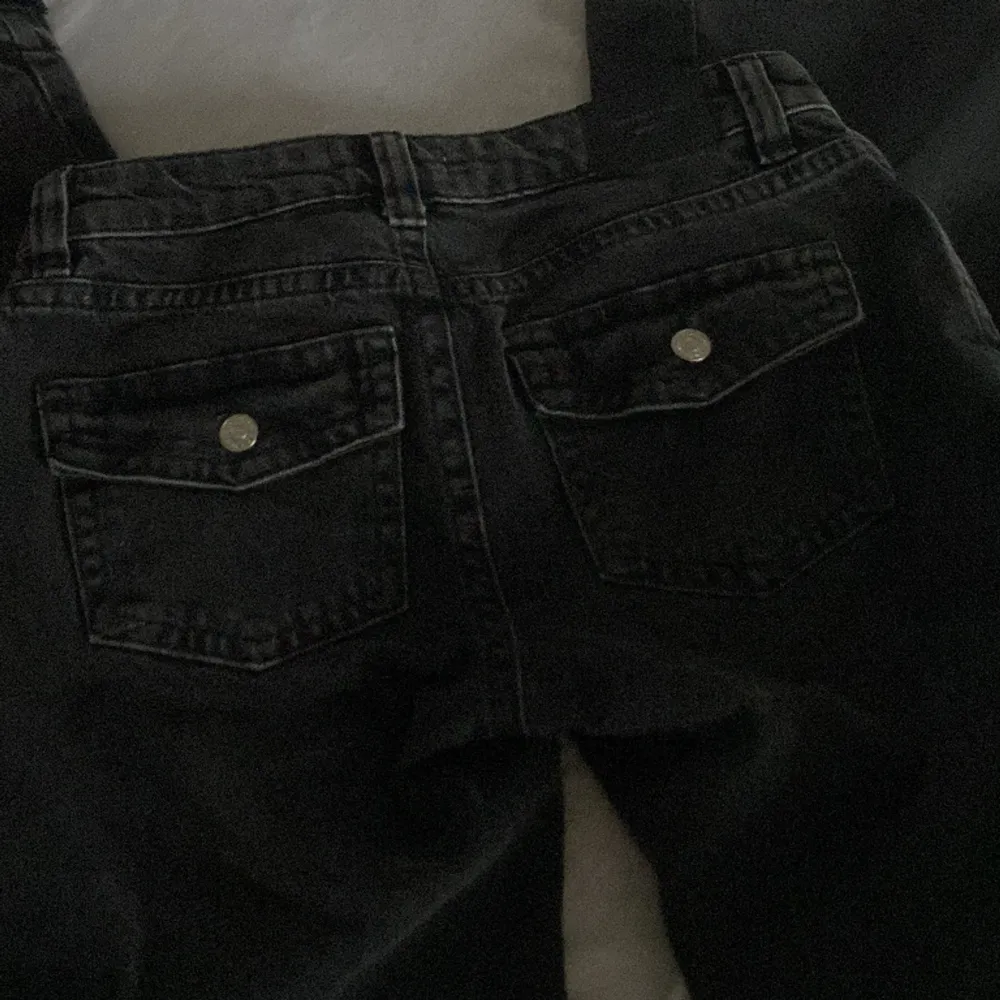 Säljer mina svarta low waisted jeans med knappar på bakfickorna från gina som nu är slutsolda.❤️ jättefina, säljer för att jag redan har en massa andra jenas❤️❤️ dom är sprättade nere vid benet. Jeans & Byxor.
