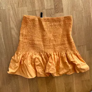 Orange kjol med volang, använd en gång :)