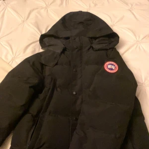 Canada gosse wyndham parka - Storlek M canada goose köpt i december varm tjock och skön utan päls eftersom pälsen blev sliten om ni vill ha mer bilder på bevis så skriv dm :)