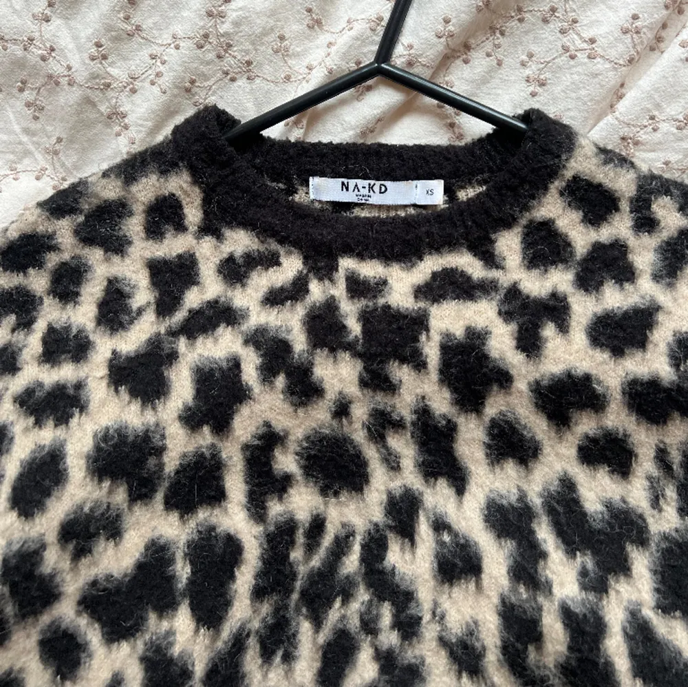 Från hemsidan:  Den här tröjan har en luddig yta, ett leopardmönster, en rundhals, långa ärmar och en bekväm, avslappnad passform.  Tröjan använd sparsamt i storlek xs. Samma storlek som modellen på bilden använder.. Stickat.