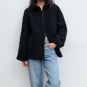 Mörkblå teddyjacka med dragkedja - Mysig svart teddyjacka från Gina tricot  med hög krage och hel dragkedja framtill. Jackan har en loose passform och är tillverkad i mjuk fleece som håller dig varm. Perfekt för kyliga dagar och enkel att styla till jeans eller kjol.