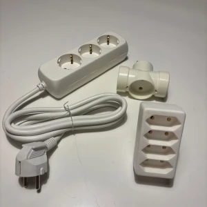 Grenuttag och eladaptrar - Paket med ett 3-vägs grenuttag med kabel, en 3-vägs väggadapter och en 4-vägs väggadapter. Alla i vitt utförande och i gott skick utan synligt slitage. Perfekt för att utöka antalet eluttag hemma eller på kontoret.