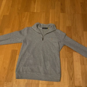 Grå half zip tröja från Polo Ralph Lauren - Säljer en Half zip från polo Ralph lauren. Den är väldigt bra skick. Kom med frågor. Pris kan diskuteras vid snabb affär. 