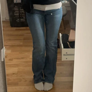 Blå bootcut jeans midwaist - Snygga blå jeans med bootcut passform och midwaist. Klassisk femficksmodell i mjukt denimtyg som sitter tajt över låren och släpper ut vid vaden. Perfekta för en avslappnad och trendig look.
