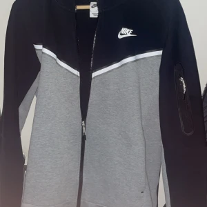 Nike ziptröja svart och grå - Nike tech fleece zip tröja, grå svart. Använd fåtal gånger så är som nyskick. Finns inga skavanker på den så den är som ny!😀