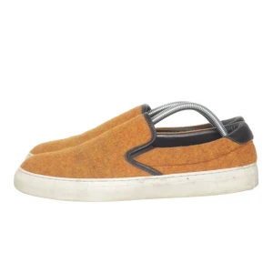 Orange Diemme slip-on sneakers i ull och skinn - Snygga slip-on sneakers i orange ull med svarta skinn-detaljer runt öppningen och hälen. Skorna har vit platt sula och en enkel, stilren design. Perfekta för dig som gillar en unik och bekväm look. Storlek 42. Nypris ca 3000kr och jag säljer dom för bara 800kr
