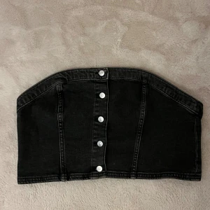 Denimtopp - Svart/grå korsettopp/bandeau med knappar i jeansmaterial. Lite mindre i storlek.
