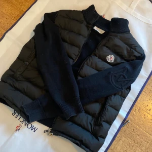 Moncler Cardigan  - Storlek S, sitter väl bra på någon som är 170 eller mindre. Moncler Garderob medföljer, samt alla taggar, etiketter och liknande. Kvitto saknas. Galjflärpen är trasig, då ena sömmen lossnat. Säljer då den inte passar. Denna cardigan är otroligt stilren och är perfekt för dig som vill bli lite extra varm och stilig till hösten. NFC funkar som det ska.