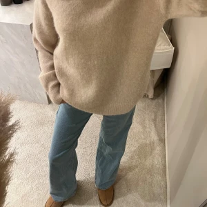 Beige stickad tröja från H&M - Supermjuk och fluffig beige stickad tröja från H&M i ull- och alpackablandning. Rund hals, långärmad och loose fit som ger en chill vibe. Perfekt att styla med jeans eller över en klänning för en snygg look. Köpt för original priset!! Endast använd någon enstaka gång!!