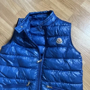 Moncler väst - Hej! Säljer min moncler väst i storlek 14 y då jag inte använder den nån mer. Det är en gamlare modell och den har ett litet märka vis Bröstet som ej syns. Skick 6-7/10