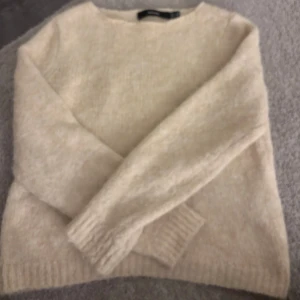 Beige stickad tröja från Vero Moda - Mysig beige stickad tröja från Vero Moda i storlek S. Tröjan har en klassisk rund halsringning och långa ärmar med ribbade muddar. Perfekt för lager-på-lager och chill höst- och vinterstil.