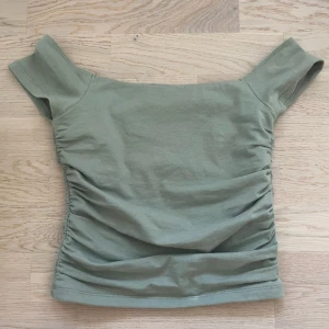 Grön offshoulder topp Hollister S - Snygg ljusgrön offshoulder topp från Hollister i storlek S. Liten vit fläck längst ner på kanten men syns väldigt lite. Säljer då jag köpte begagnad men den var för liten. 